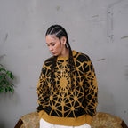 designer knit sweater with a golden geometric kaleidoscope pattern and textured structure.